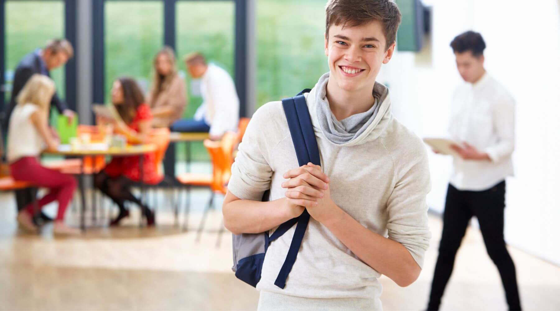 Male nursing student smiling with backpack.