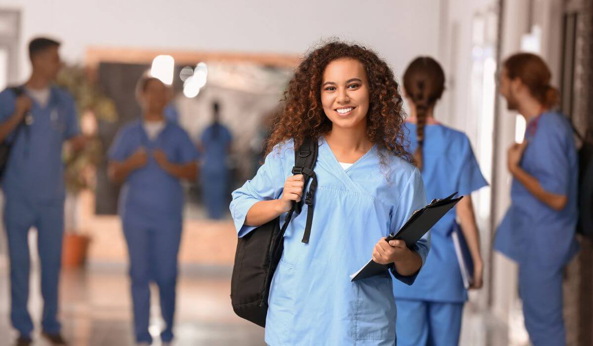 Nurse smiling in halls of hospital.
