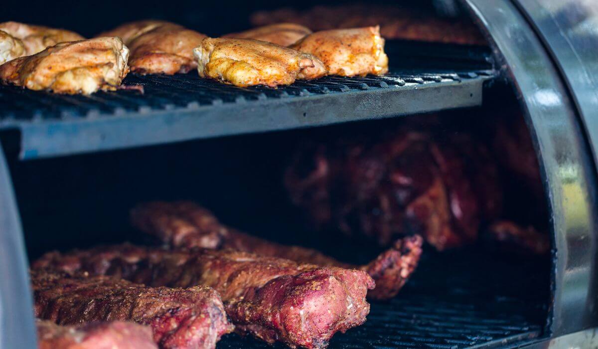 chicken and beef cooking on outdoor grill or smoker