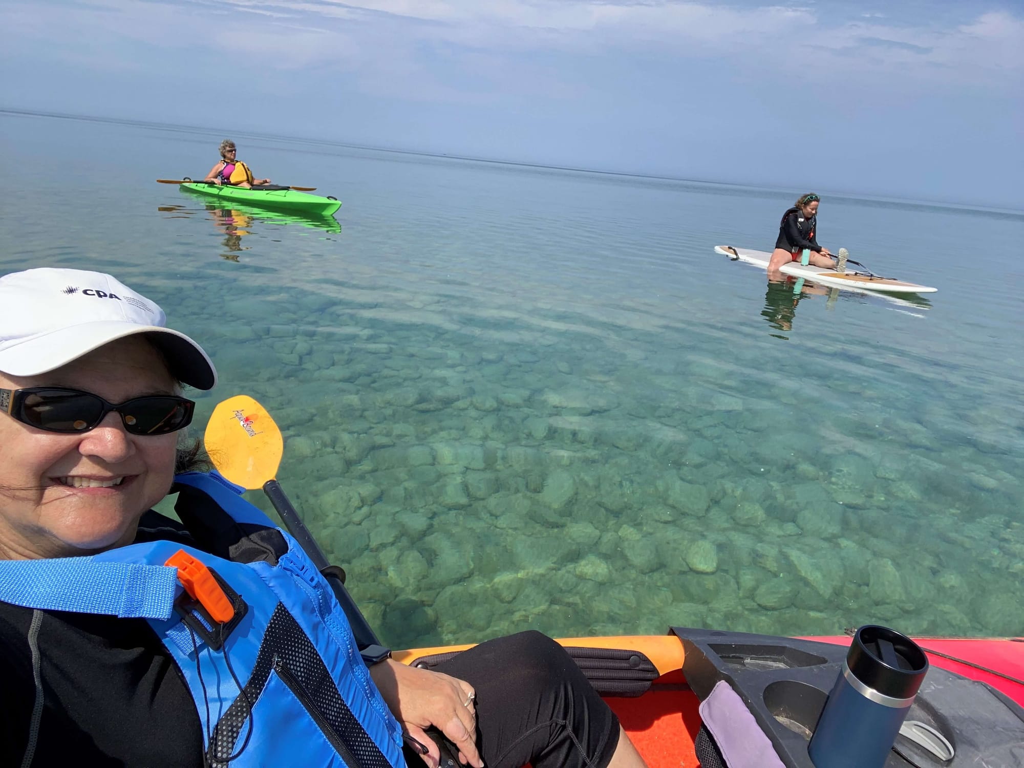 Three friends kayaking and paddleboarding in Lake Huron